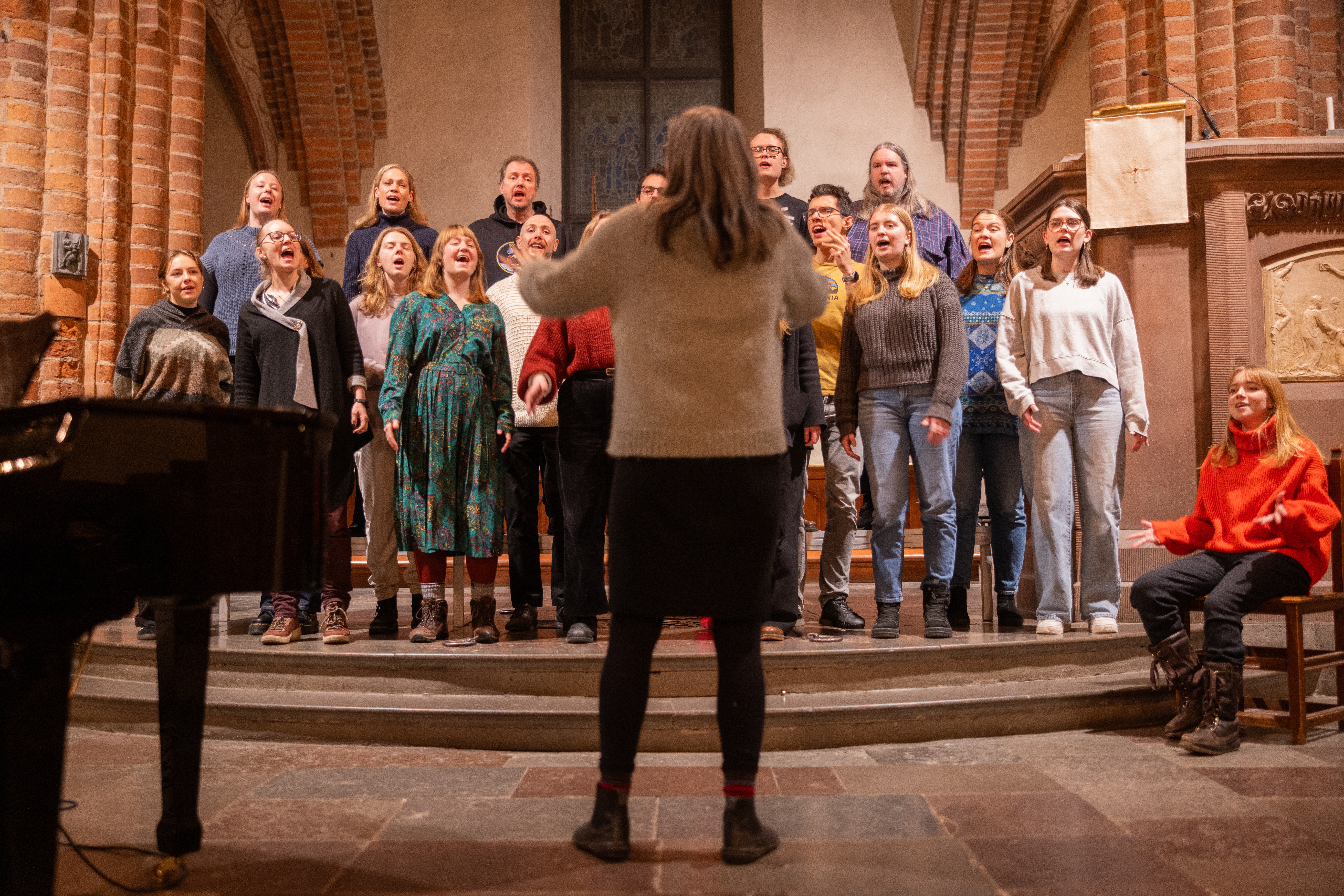 En blandad kör övar i en kyrka.