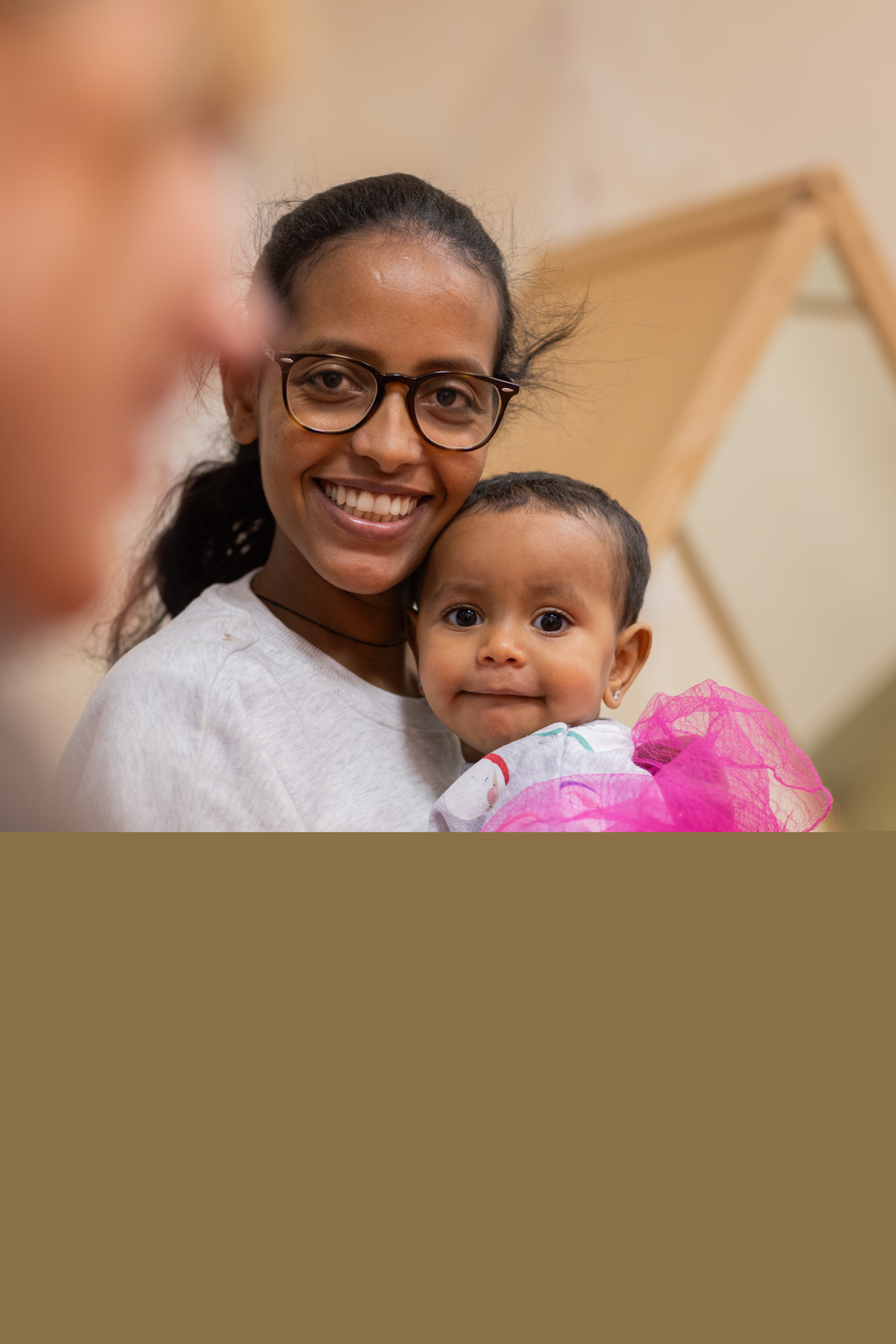 En mamma sitter med en bebis i famnen.