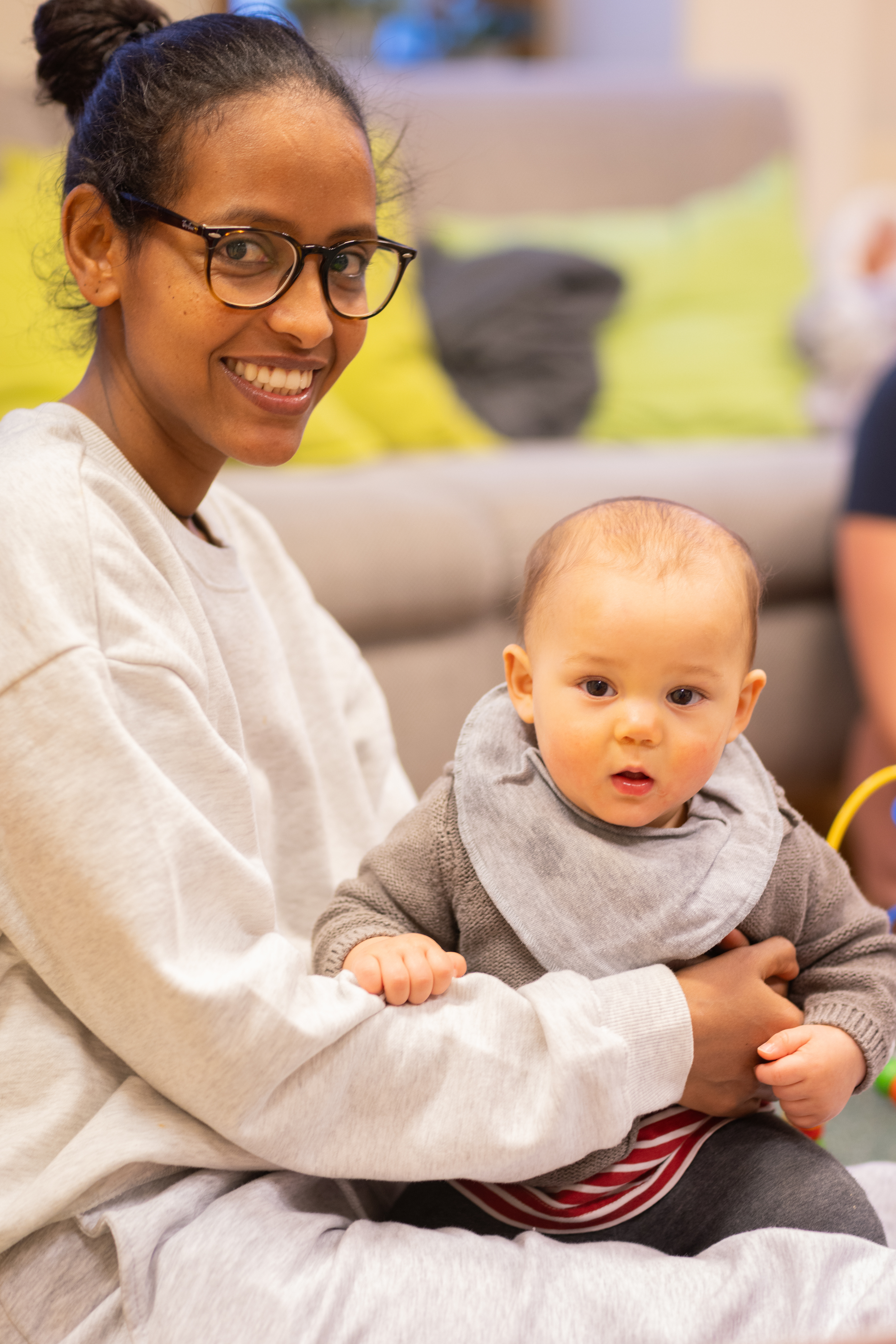 En kvinna sitter med en bebis i famnen.