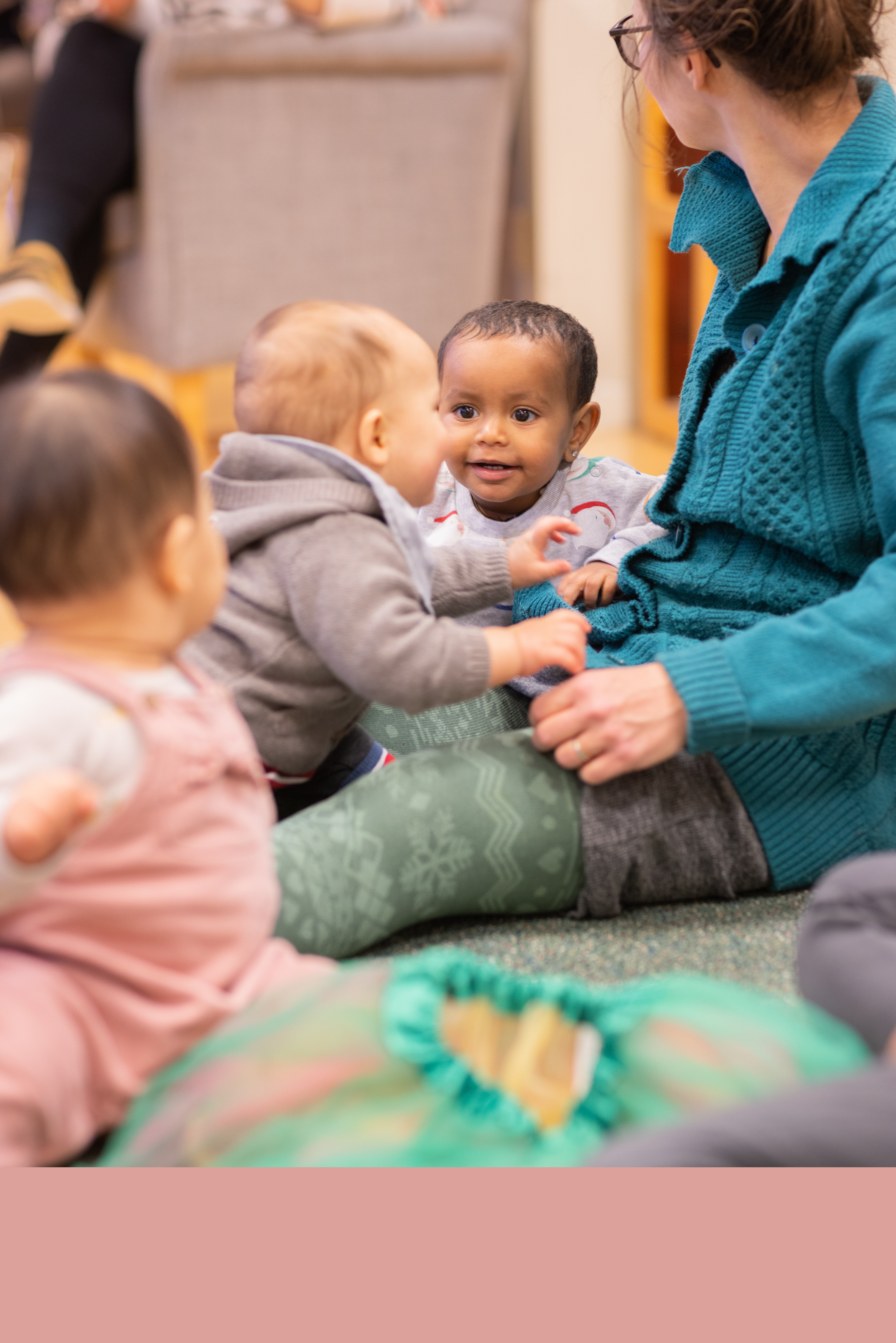 Några bebisar sitter på golvet och skrattar.