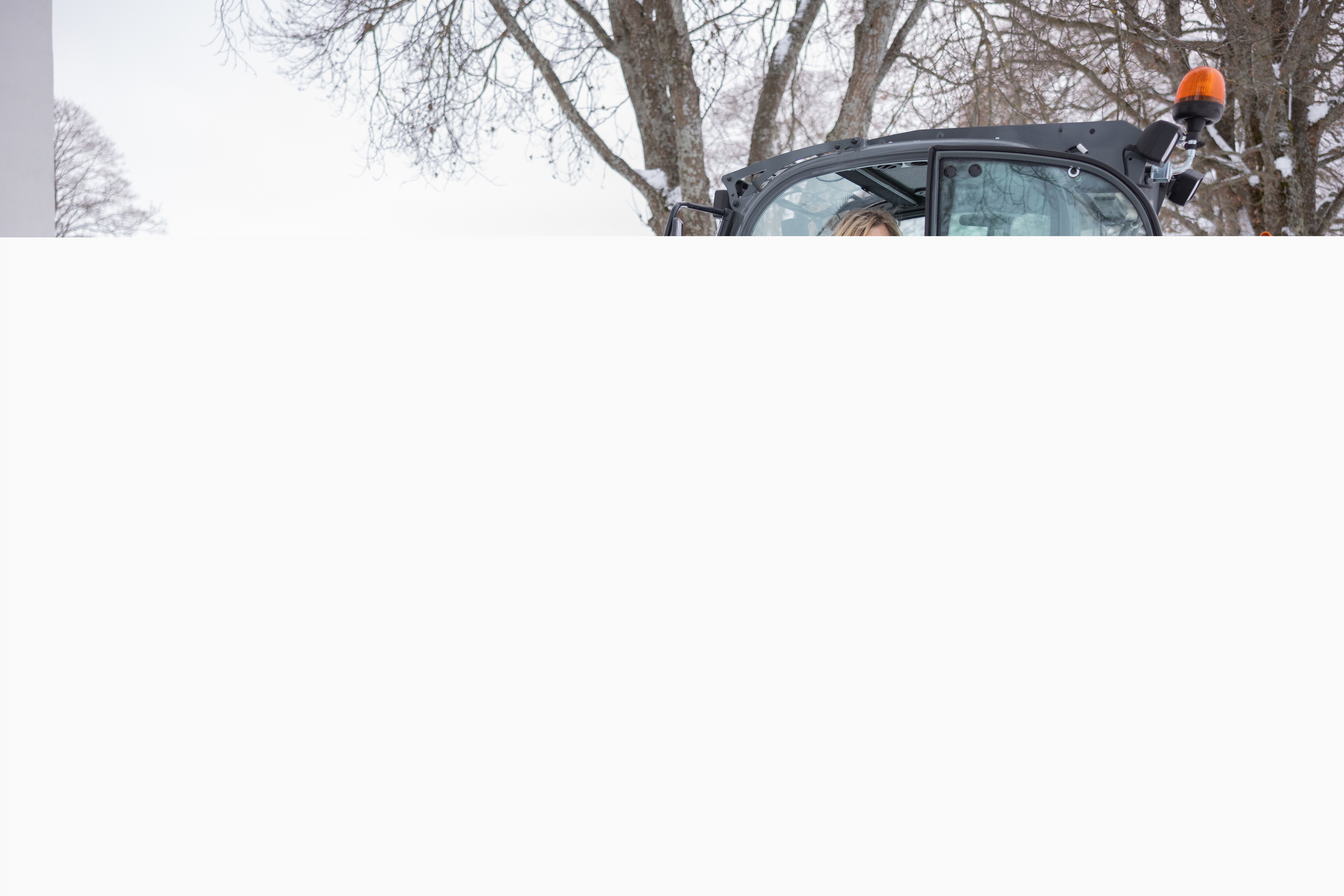 En vaktmästare skottar snö framför kyrkobyggnad.