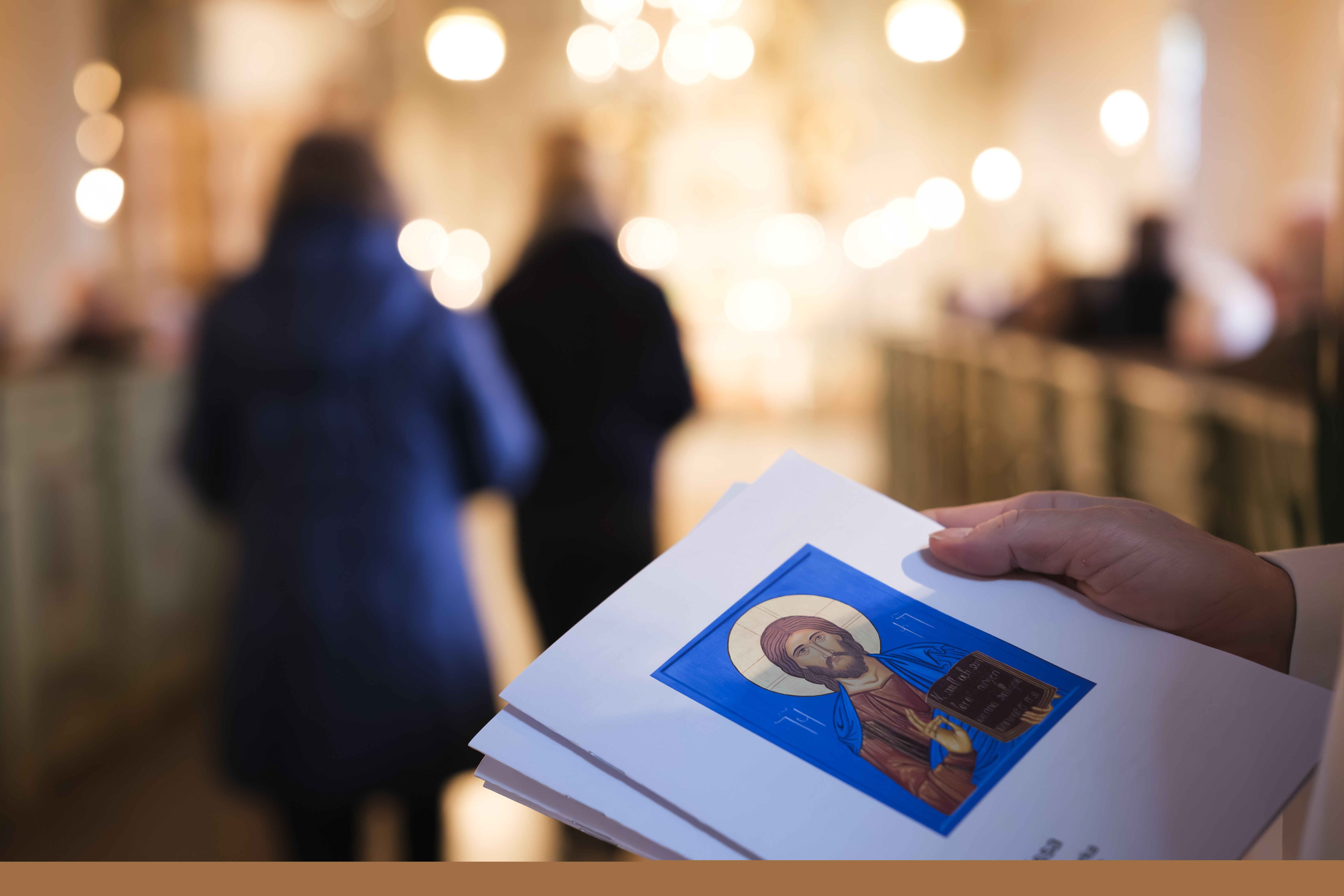 Närbild på händer som delar ut agendor. 