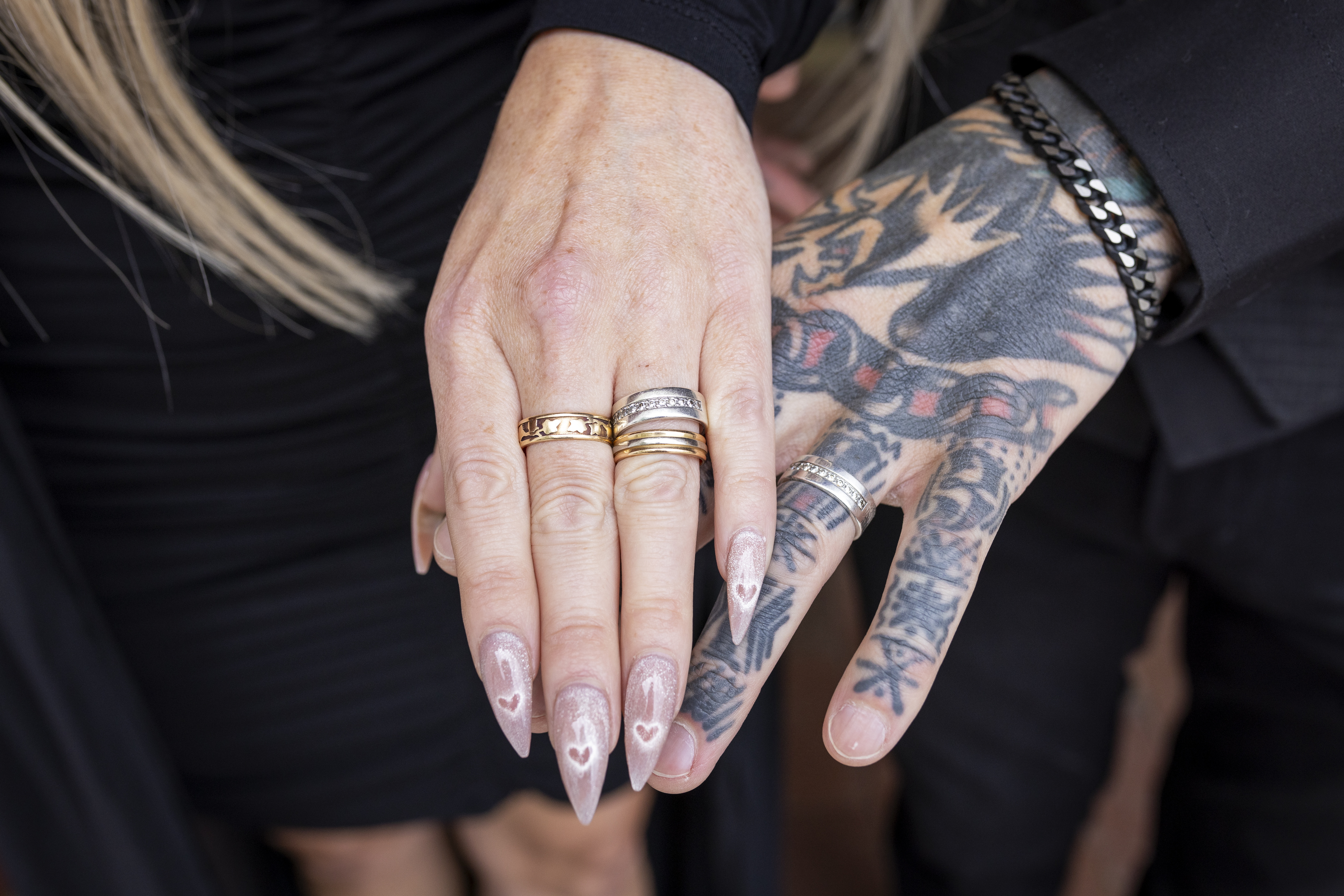 Drop-in vigsel. Närbild på två händer som bär vigselringar.