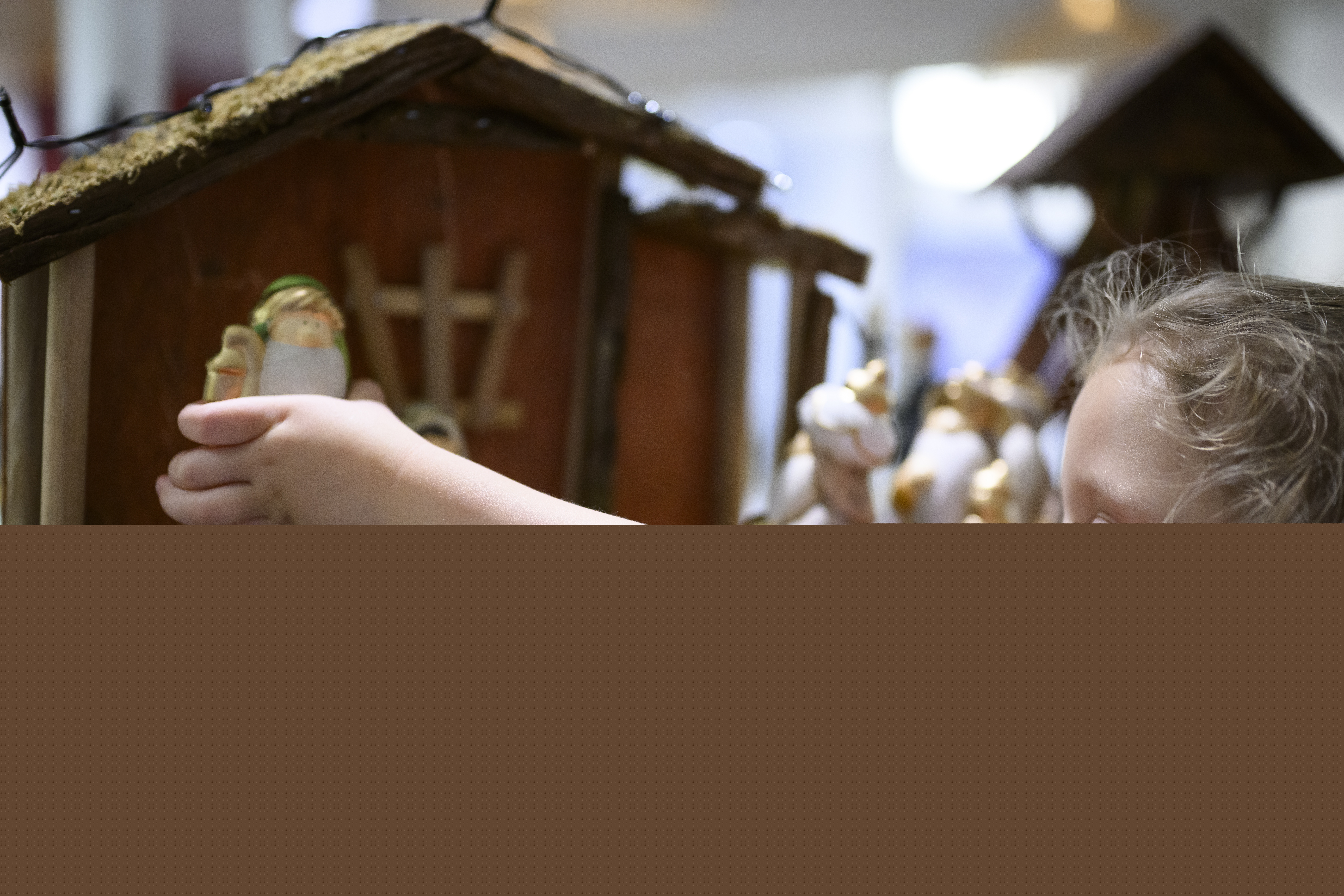 Ett litet barn leker med en julkrubba.