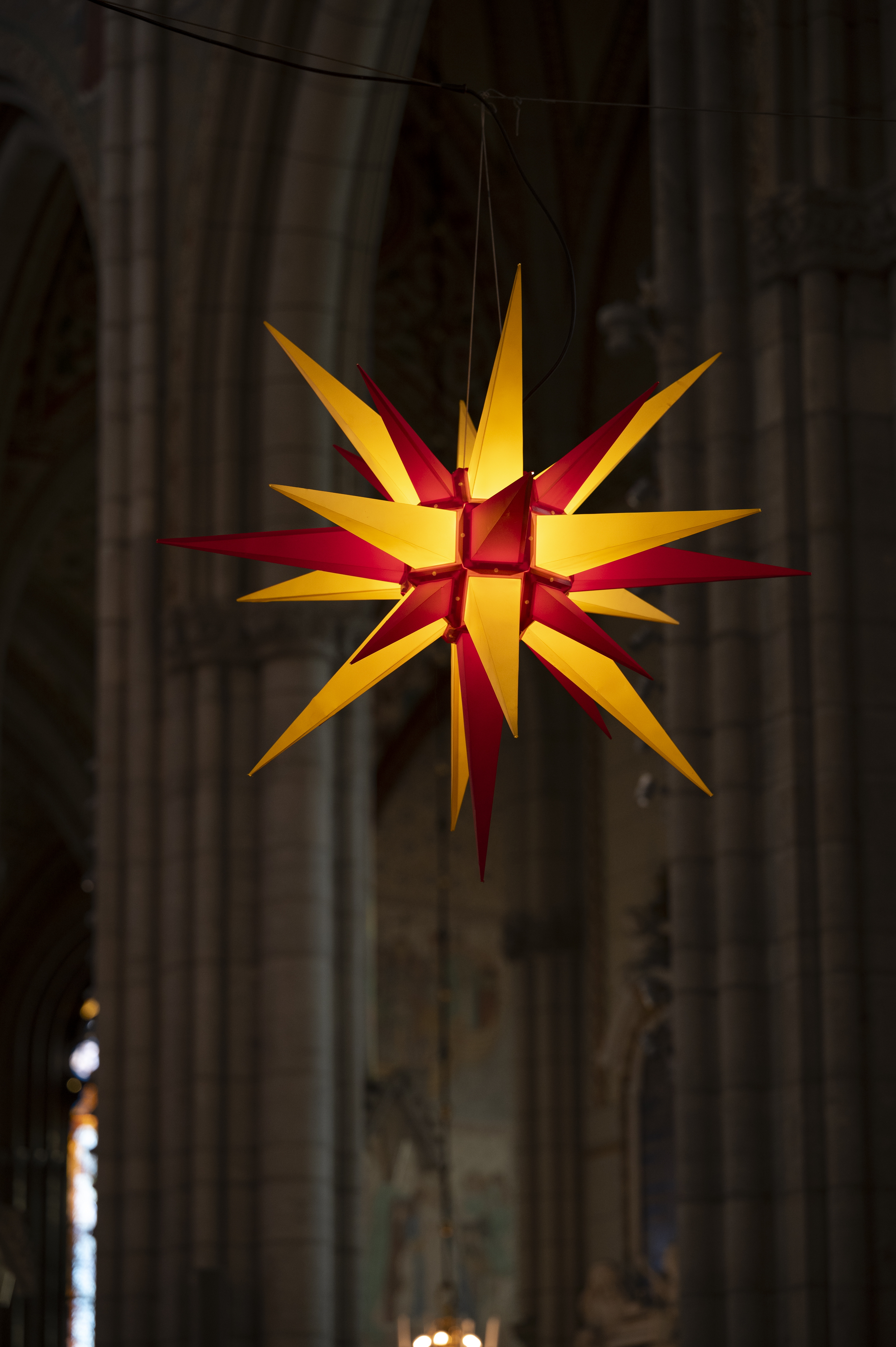 En tänd julstjärna i gult och rött hänger i Uppsala domkyrka.