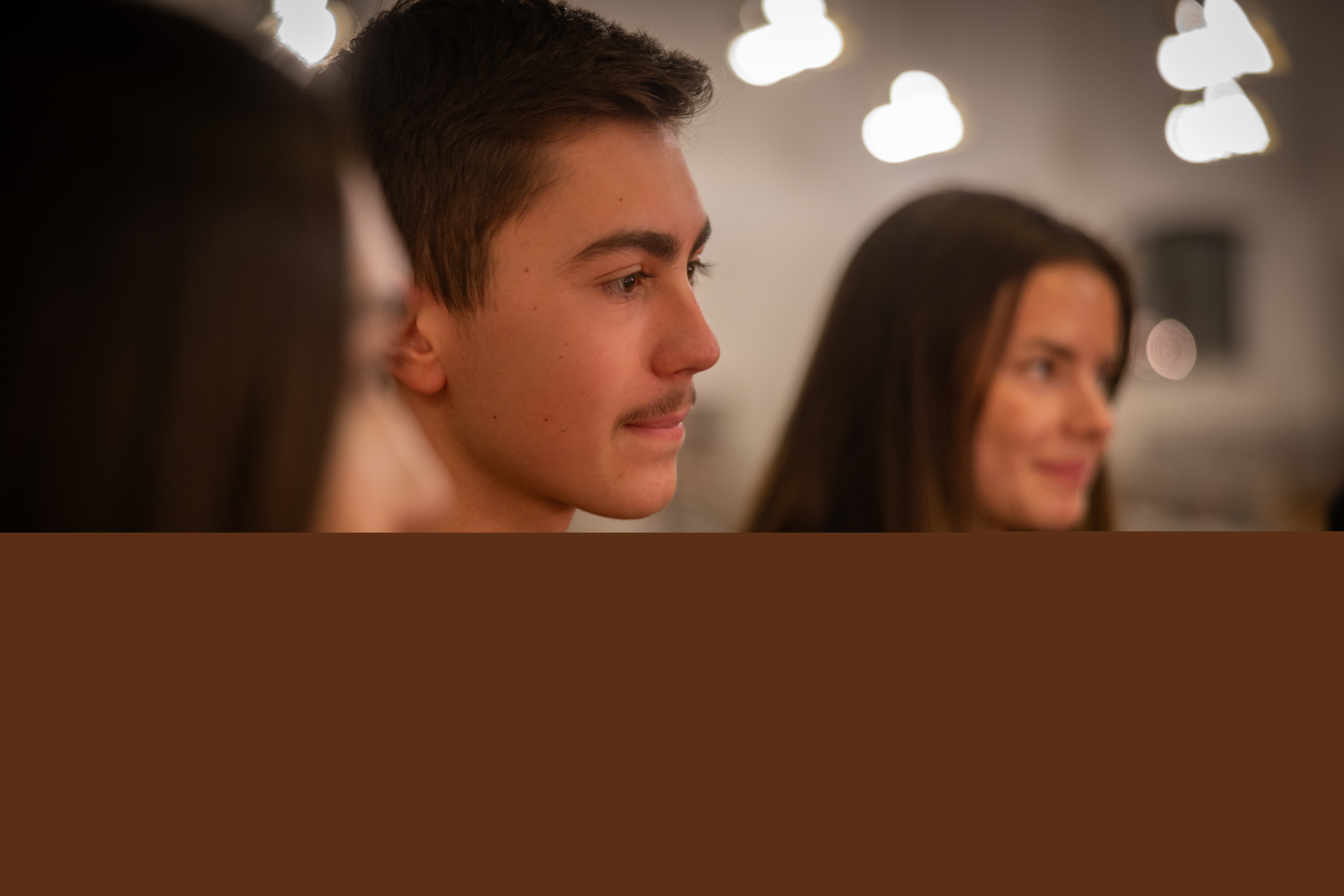 En närbild på tre ungdomar som sitter bredvid varandra.