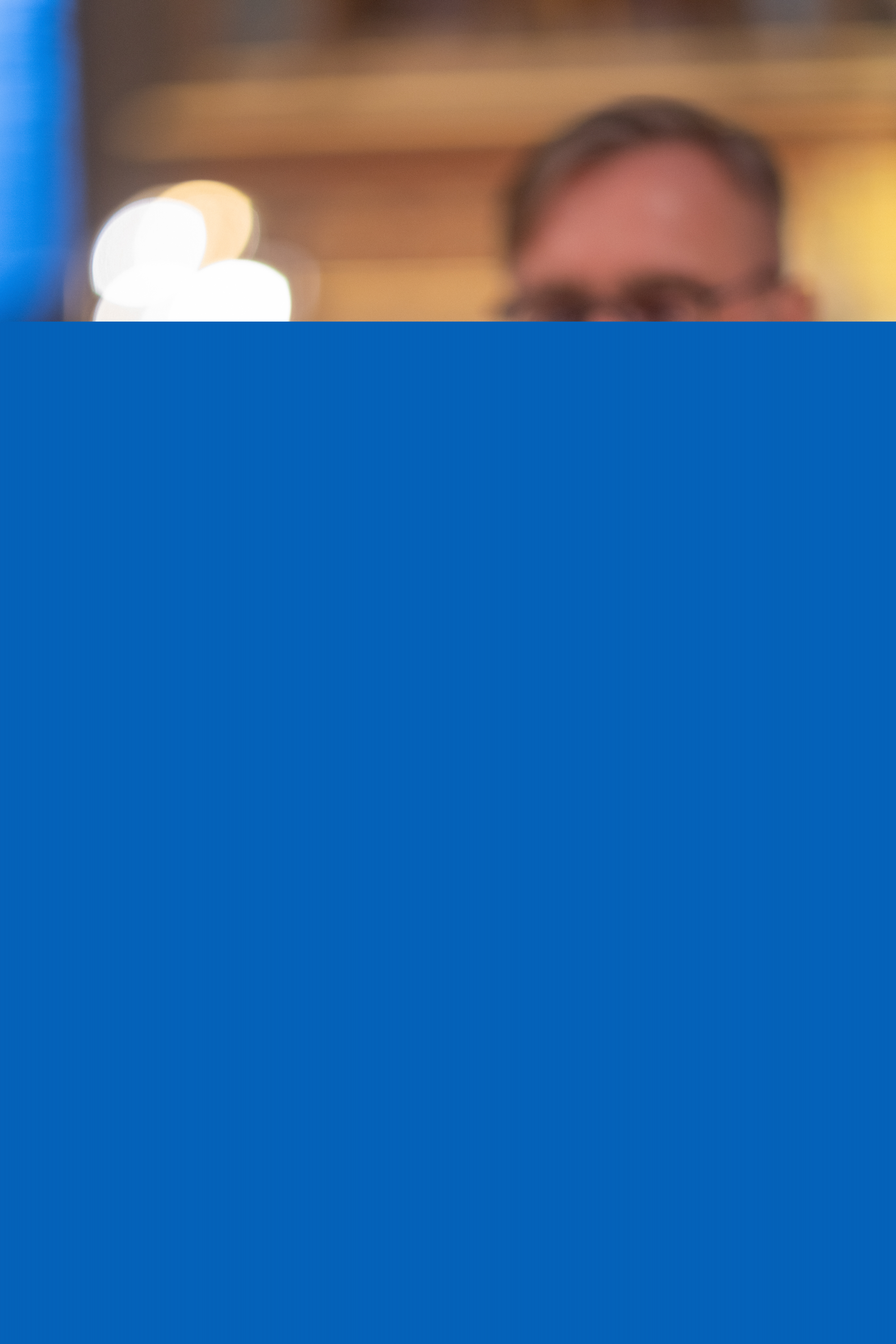 En präst lyfter upp nattvardskalken.