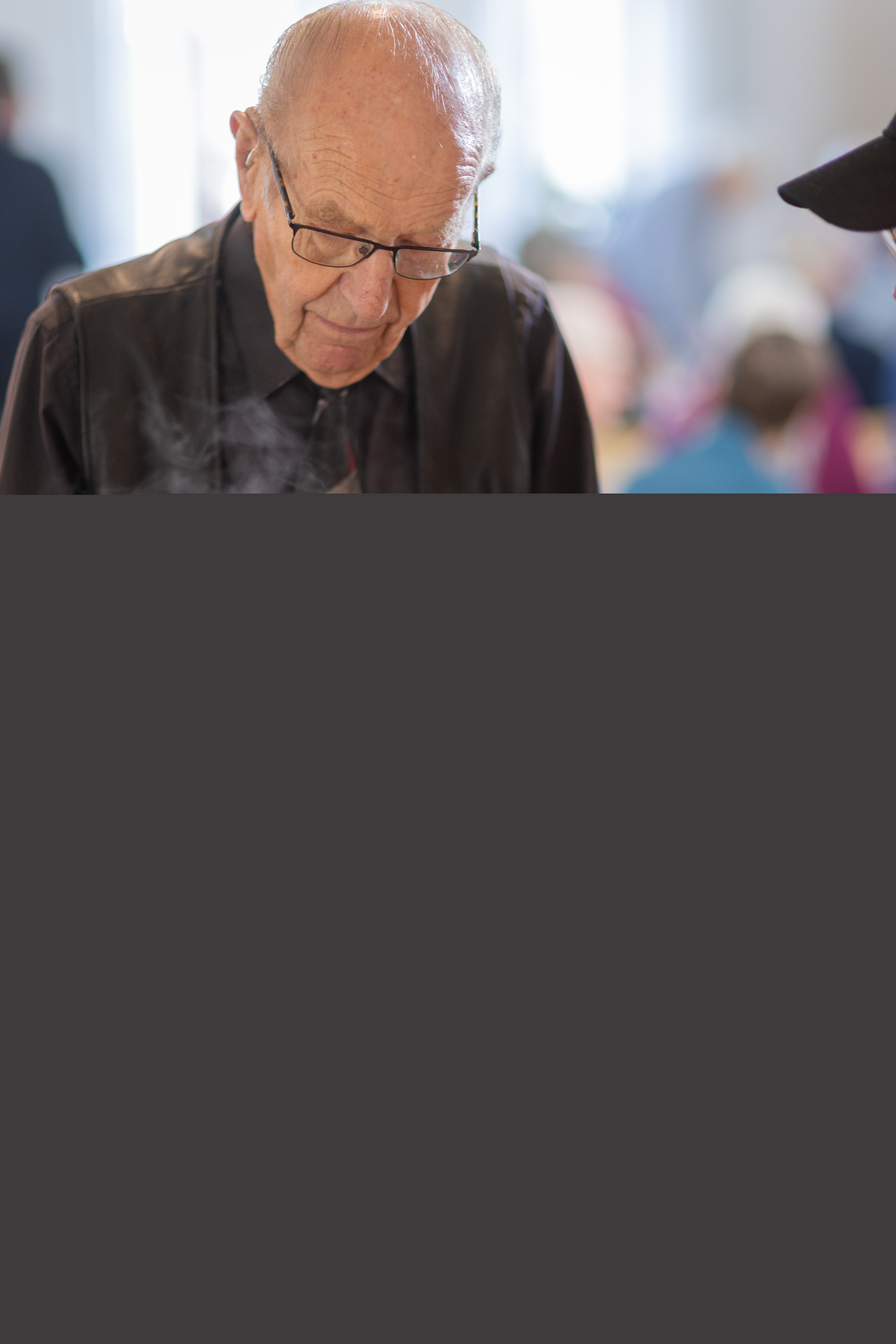 En äldre man får mat i sin tallrik i en matbespisning.