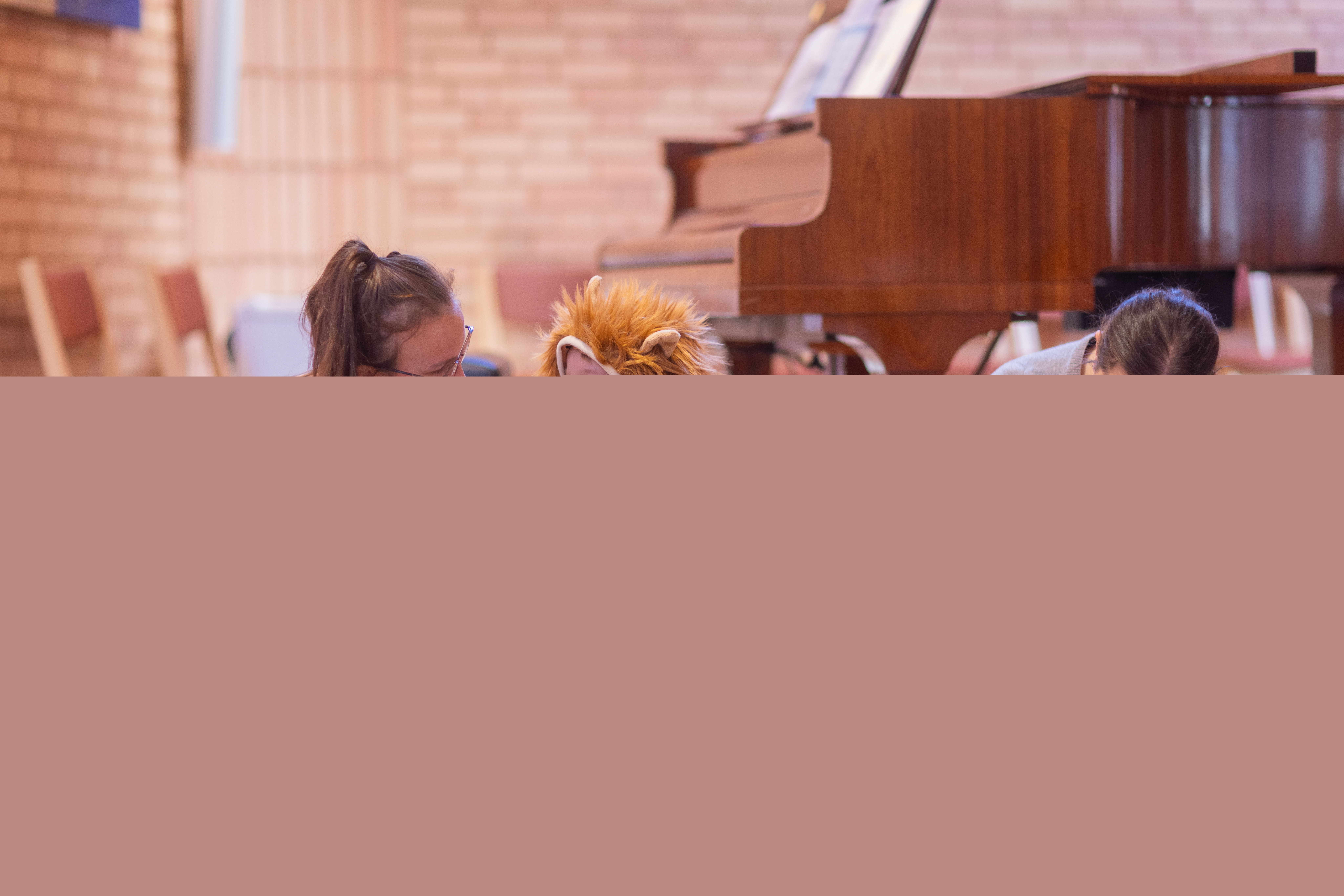 Två kvinnor sitter på golvet och leker med barnen på en öppen förskola.