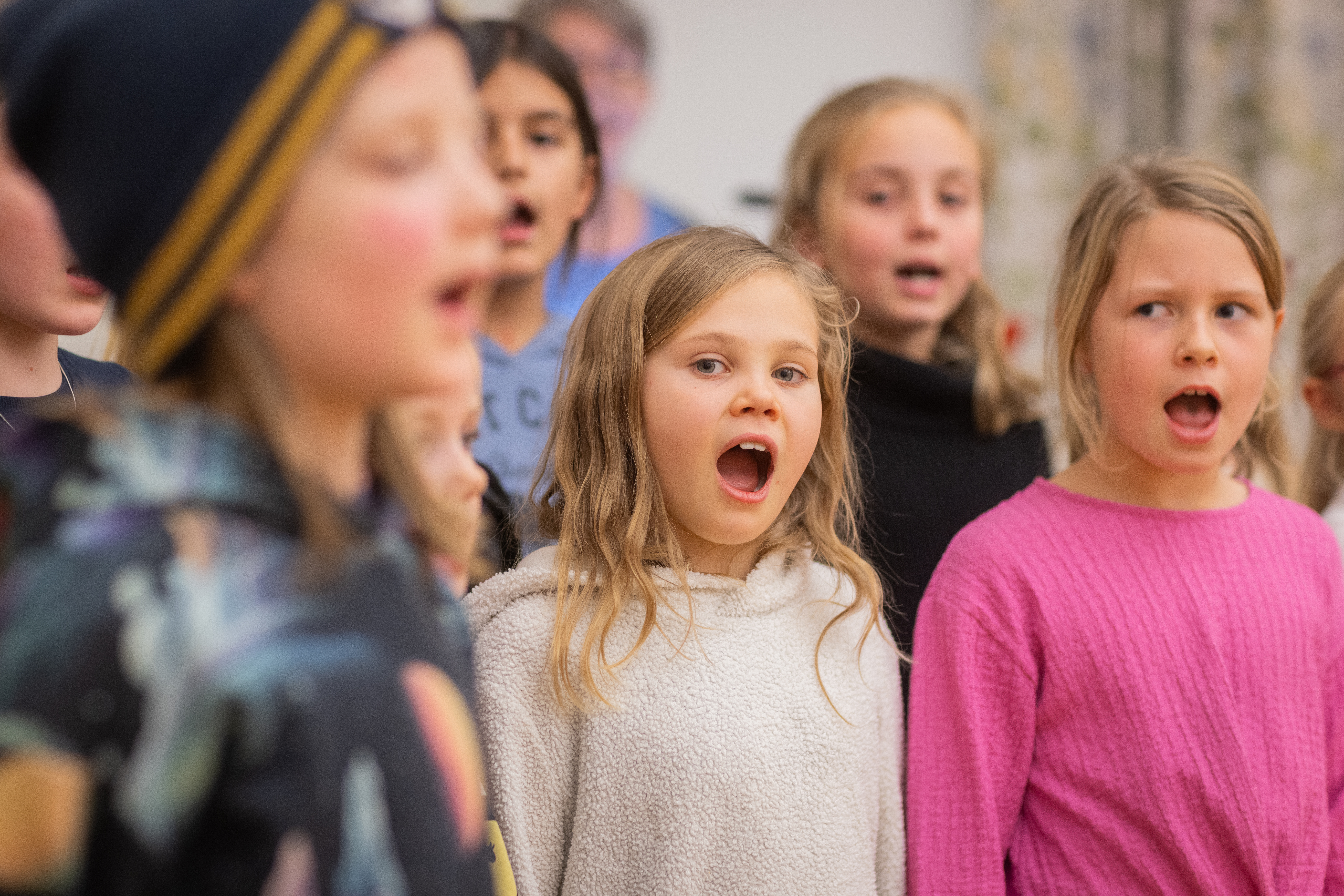 Närbild på sjungande barn i en barnkör.