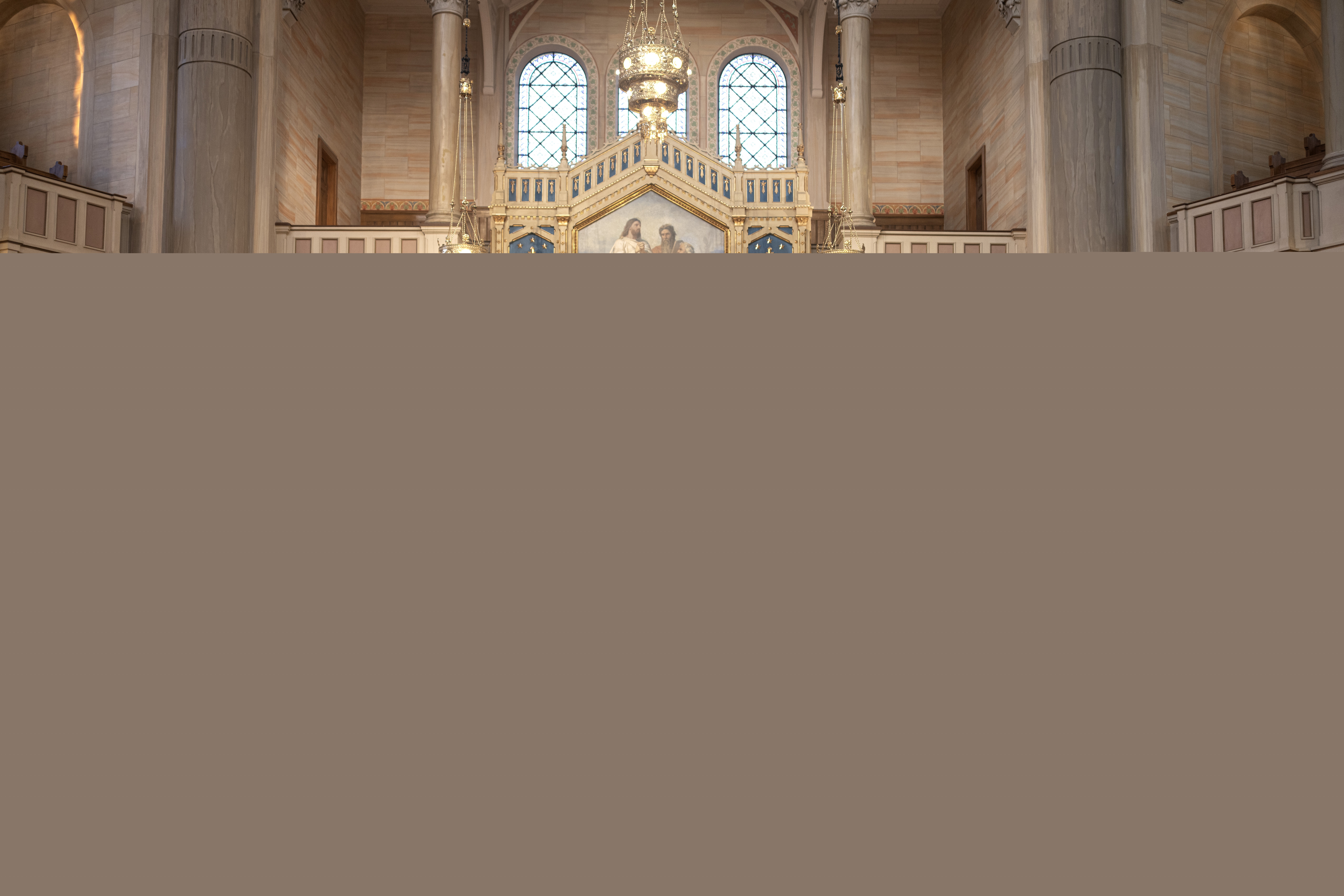 En präst och en yngre kvinna står vid ett bord längst fram i en kyrka och håller ett föredrag. Åhörare sitter i kyrkbänkarna. En regnbågsfärgad matta i mittgången.