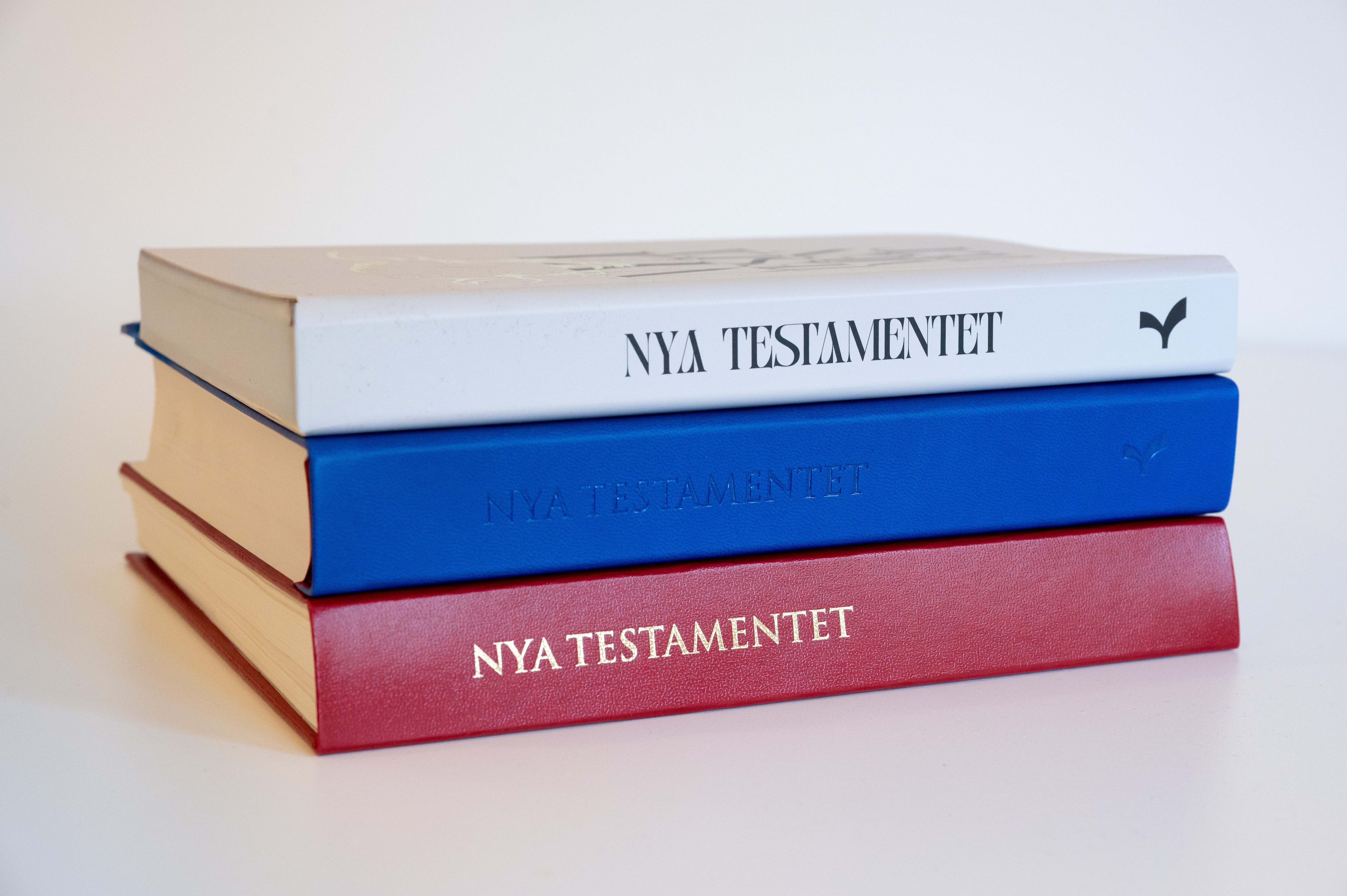 Provtryck av boken NT2026, röd, blå och vit pärm.