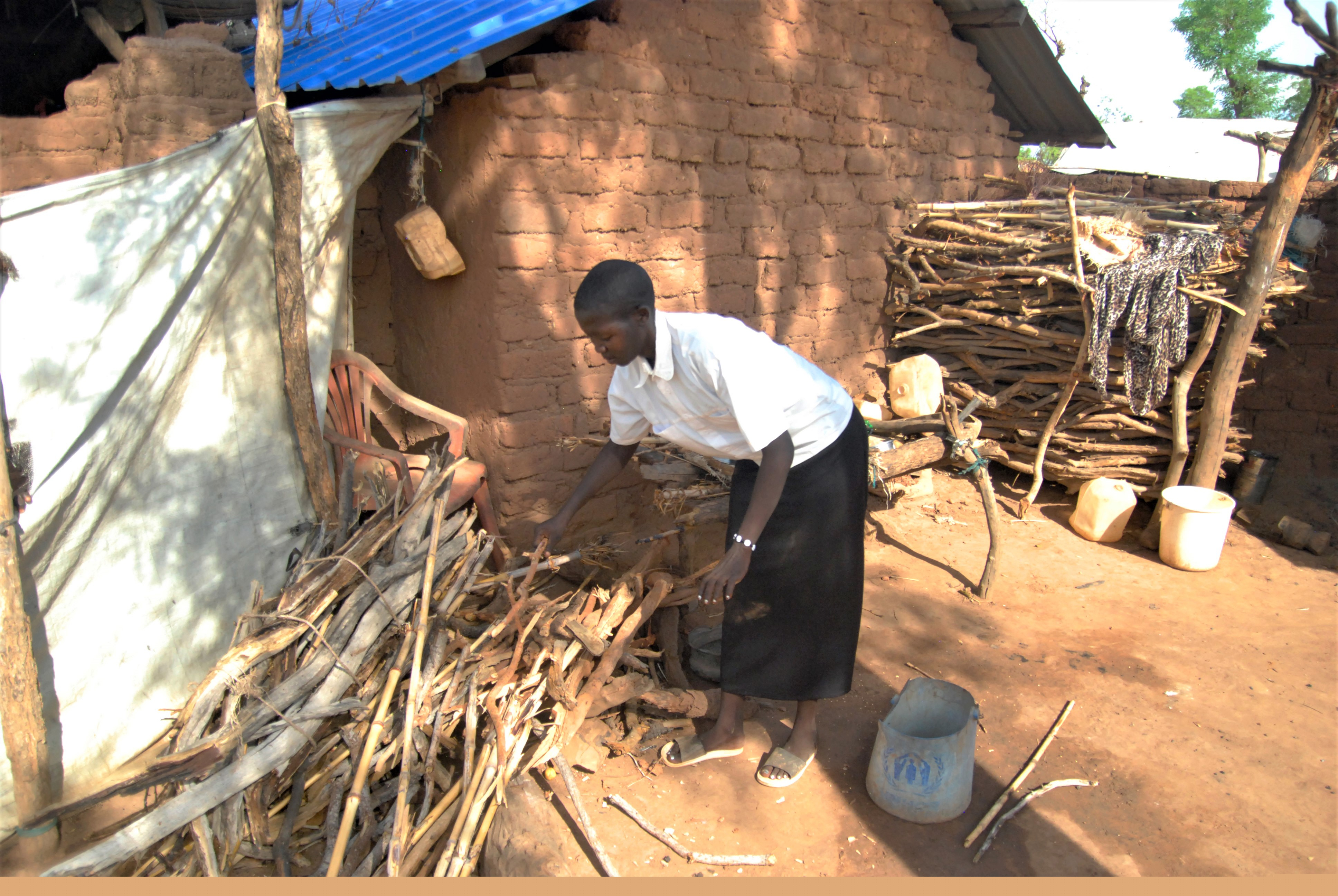 Ung kvinna samlar ved för matlagning.