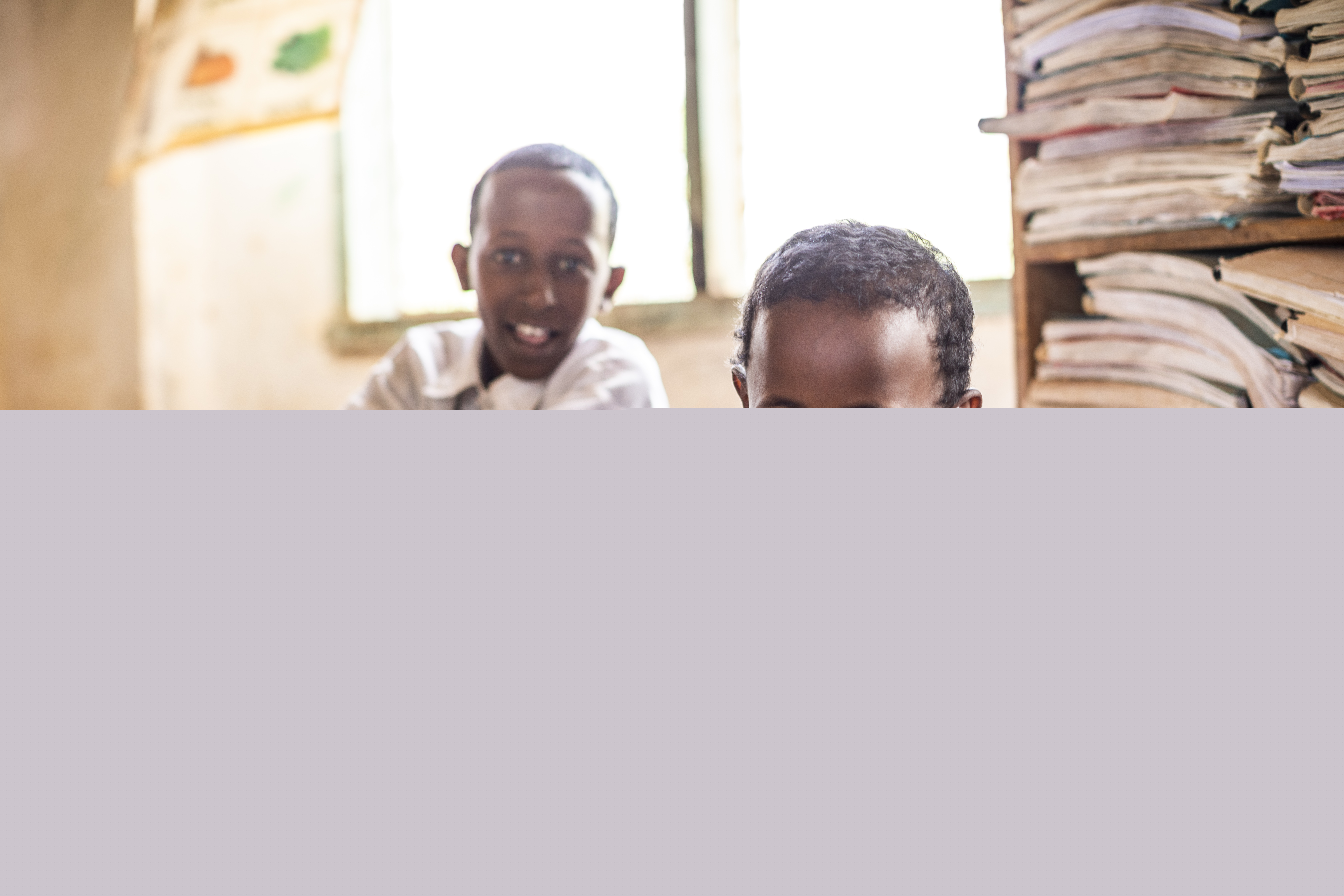 Två pojkar sitter i ett klassrum. 