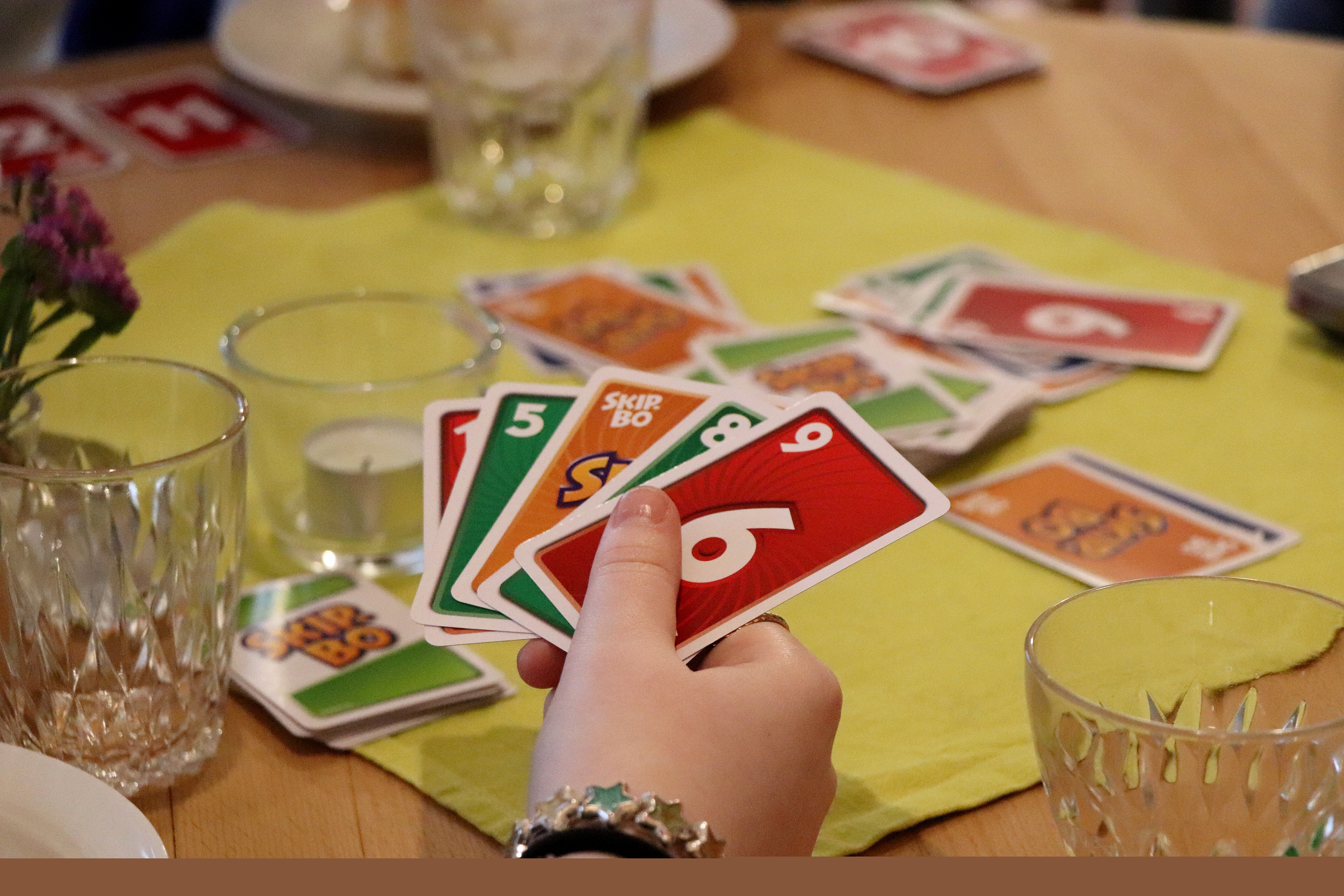 Händer som håller spelkort i olika färger.