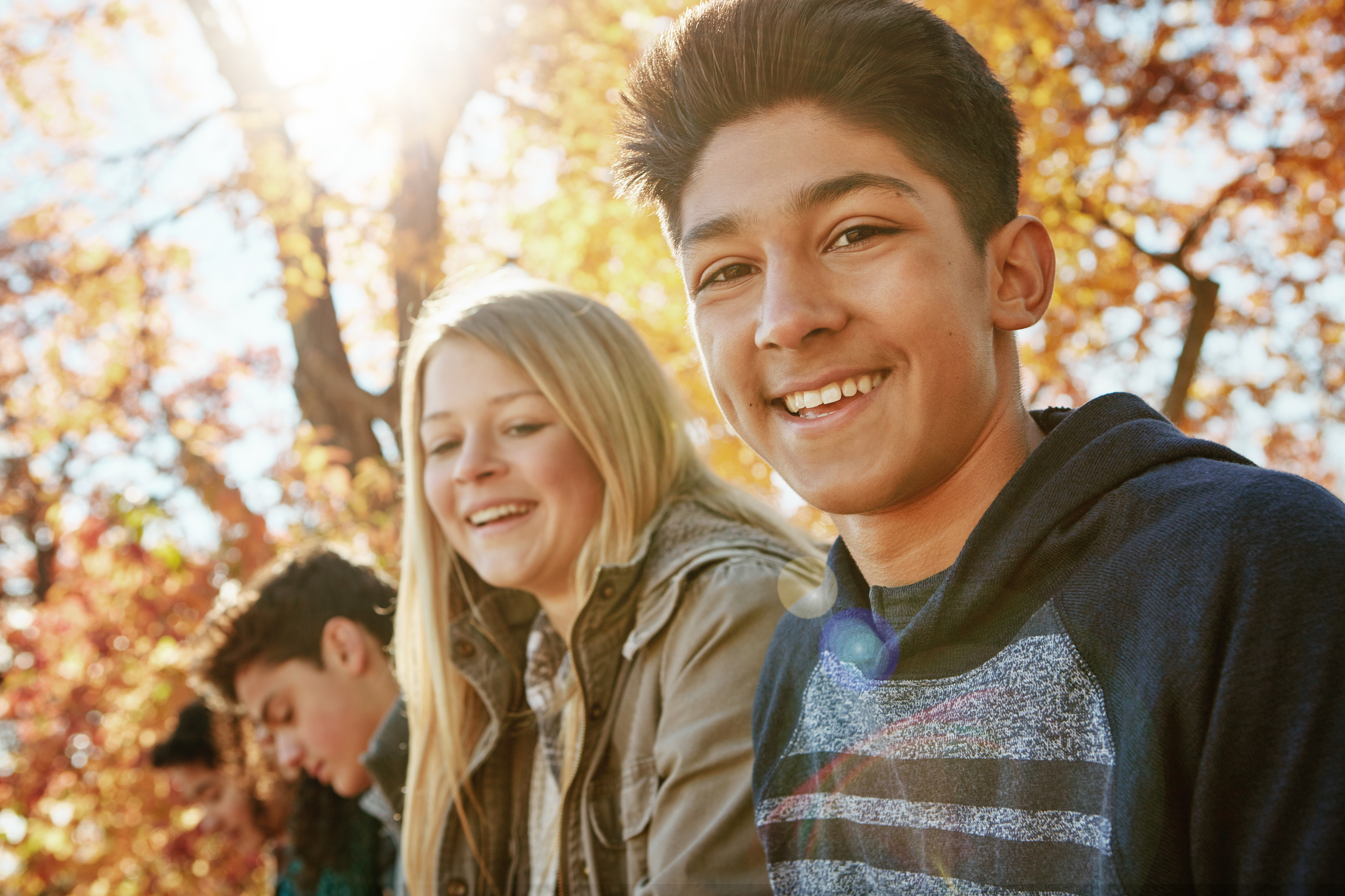 En grupp ungdomar samlade i en park på hösten.