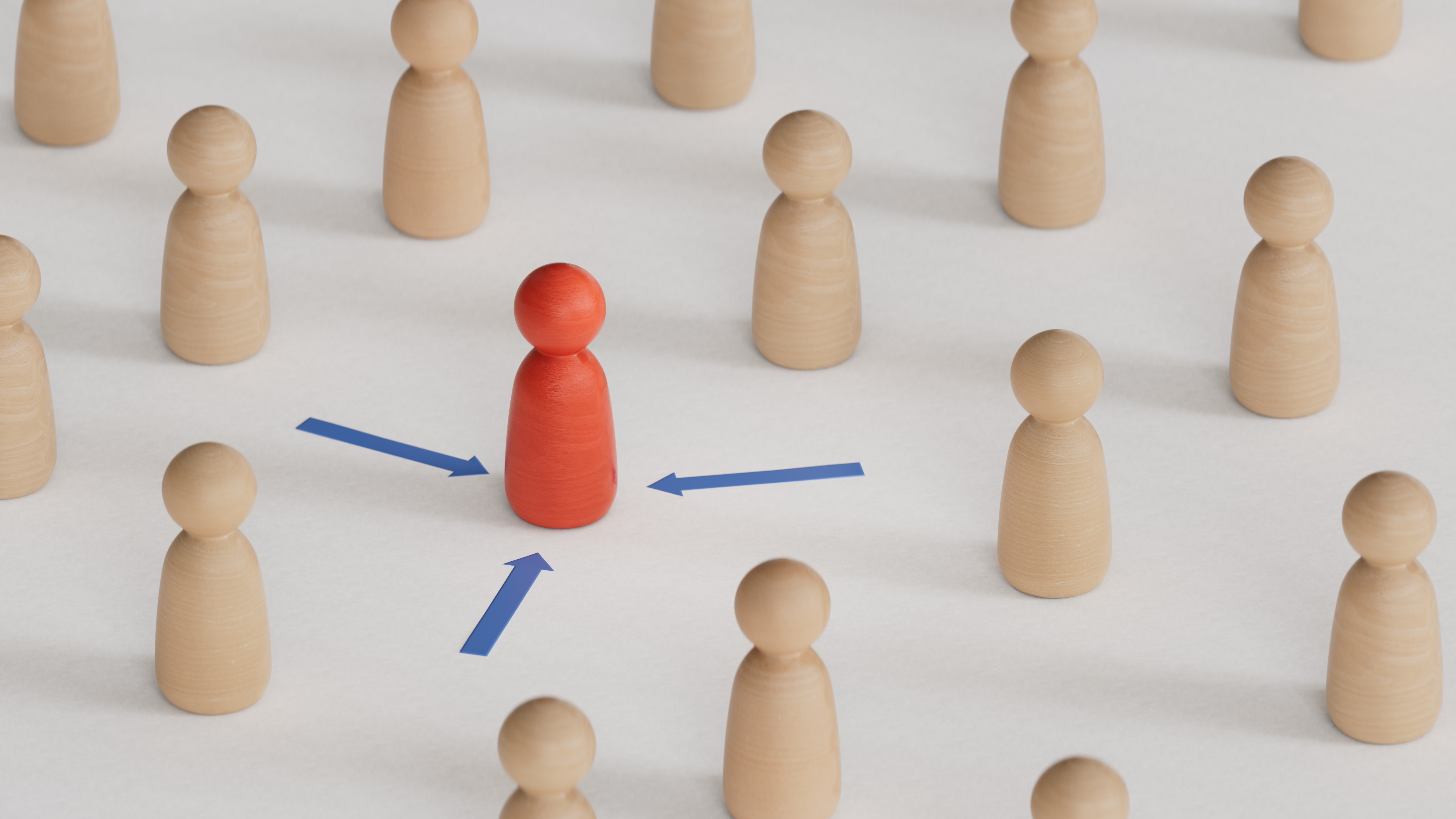 Flera spelpjäser står på ett bord. I mitten står en röd pjäs med bilar pekandes mot sig.