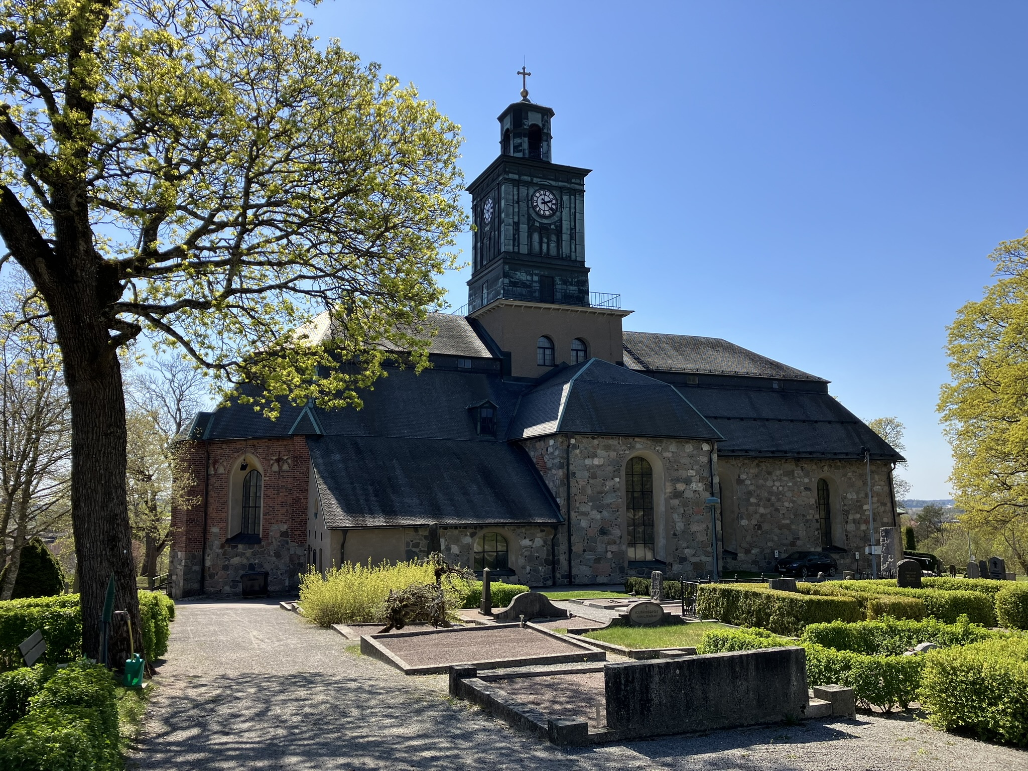 Vårfrukyrkan omgiven av grönskade träd och häckar.