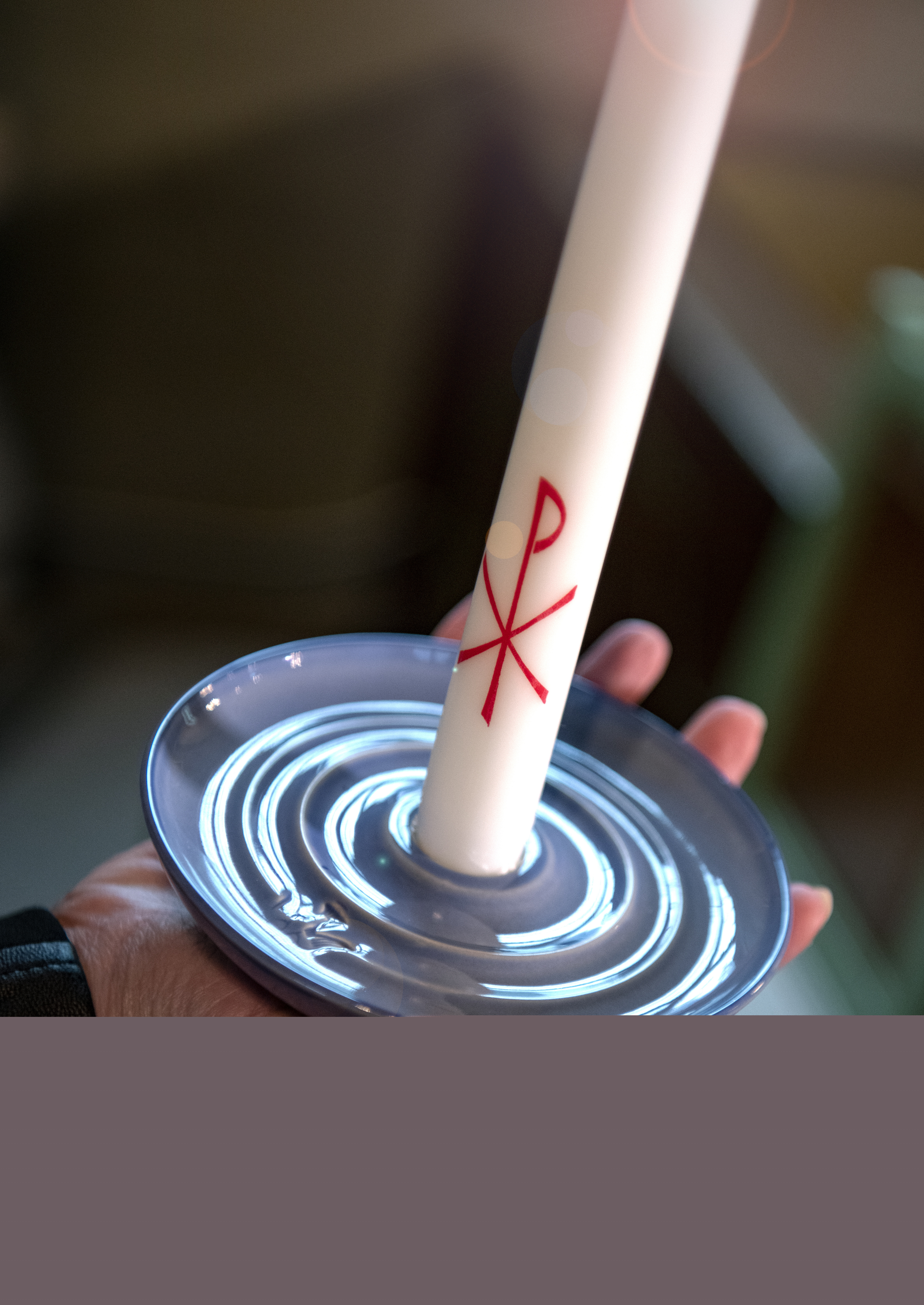 Hand håller ett dopljus.