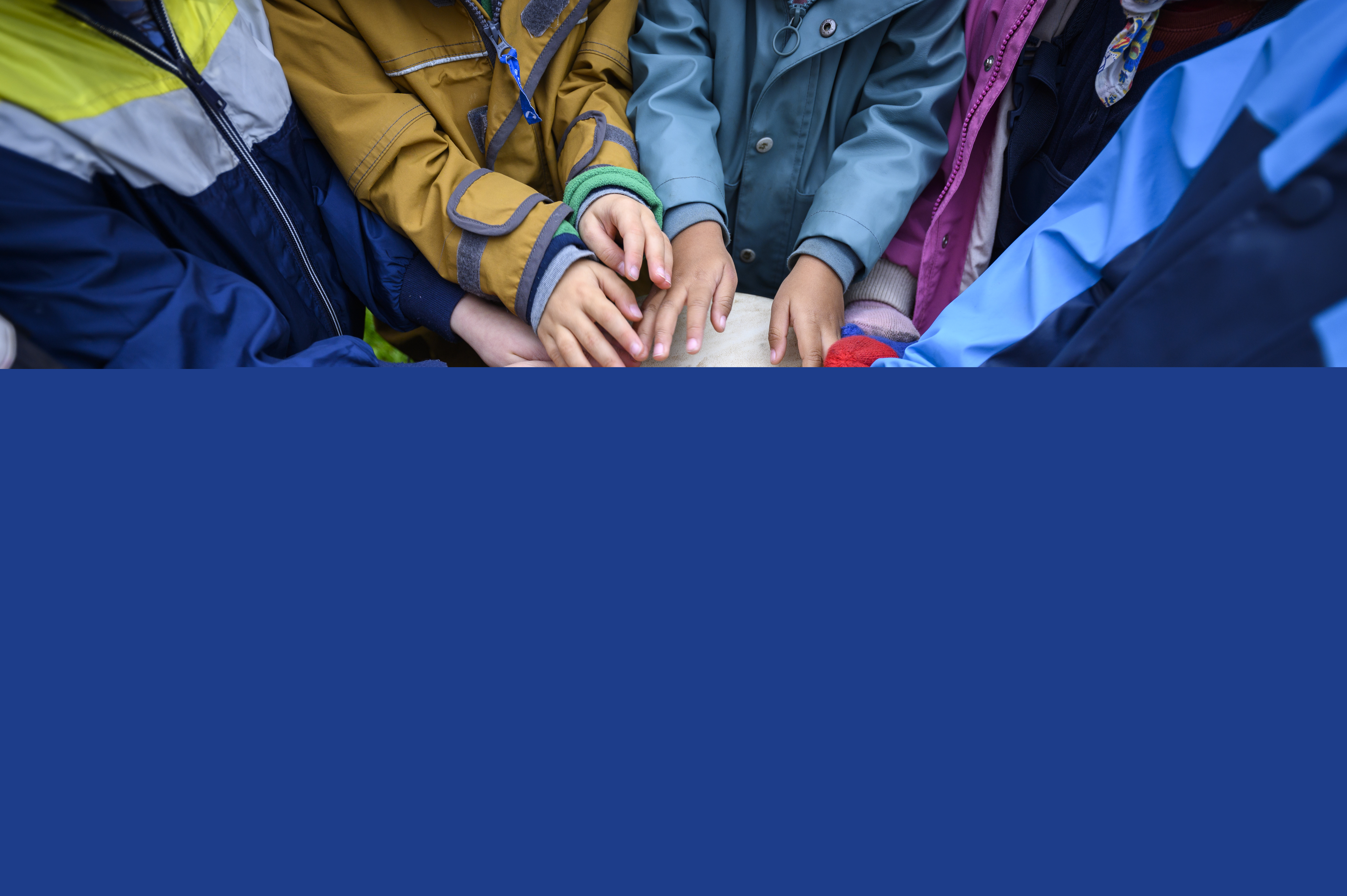 En grupp barn står utomhus och spelar på en och samma bongotrumma.