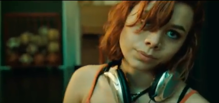 Scen från filmen Vegas. Rödhårig tjej med stora hörlurar.